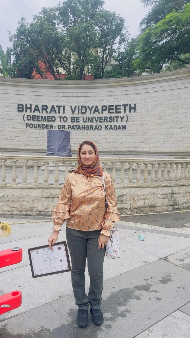 Dr. Rifat holding her certificate outside Bharati Vidyapeeth, Pune